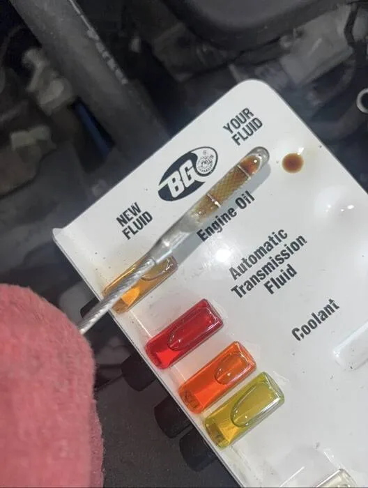 Engine oil condition compared on a BG fluid test card during a maintenance inspection