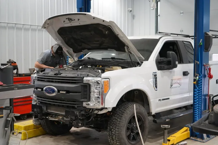 Technician working under the hood of a Ford F-250